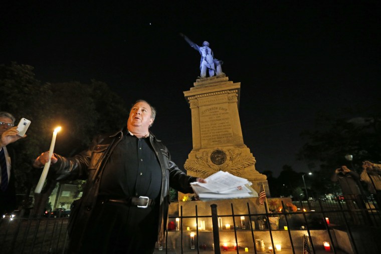 Image: Charles Lincoln speaks during a candlelight vigil