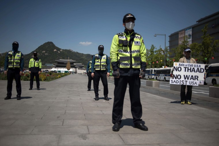 Image: A protester holds a placard denouncing the THAAD anti-missile system