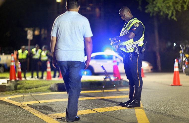 Image: A City of North Miami Beach police officer conducts a field sobriety test during a DUI checkpoint