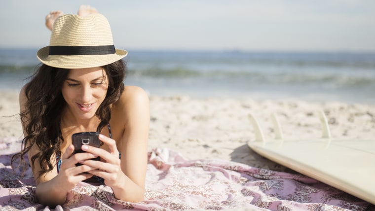Woman using cell phone on beach