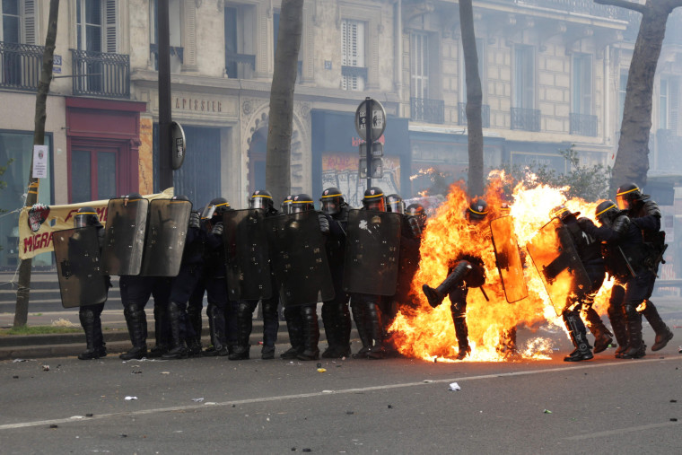 Image: French CRS anti-riot police officers are engulfed in flames