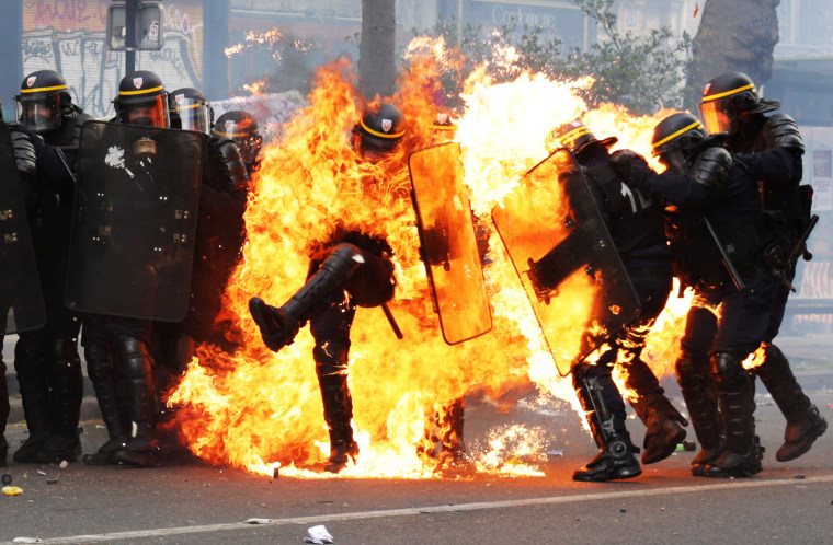 Image:  Image: French CRS anti-riot police officers are engulfed in flames