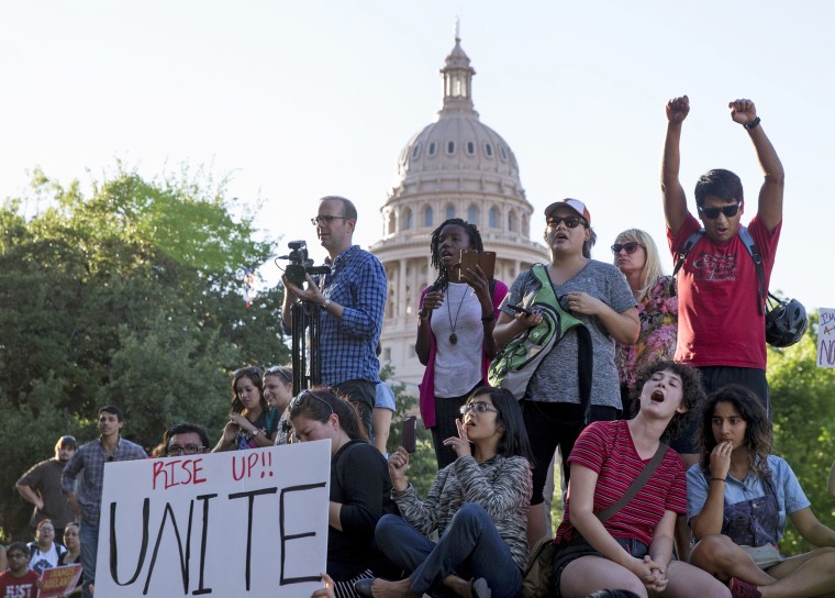 Image: Protesters, who are against the Senate Bill 4 Sanctuary Cities ban, rally outside the Texas Department of Insurance building