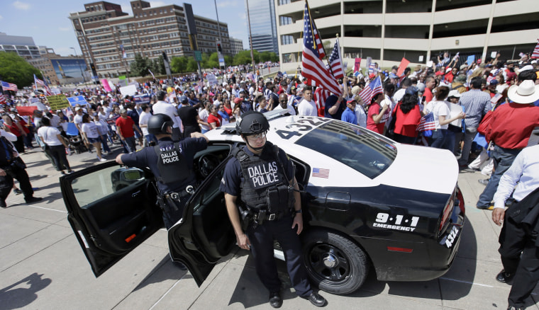 Dallas police stand guard during a march through downtown Dallas on April 9 to call for an overhaul of the nation's immigration system and end to what organizers say is an aggressive deportation policy.