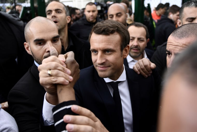 Image: Emmanuel Macron shakes hands in Sarcelles, near Paris