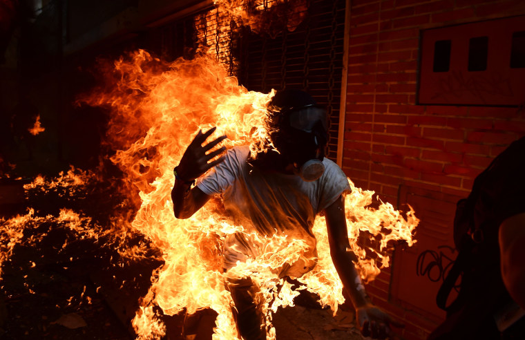 Image: A demonstrator catches fire during clashes with police 