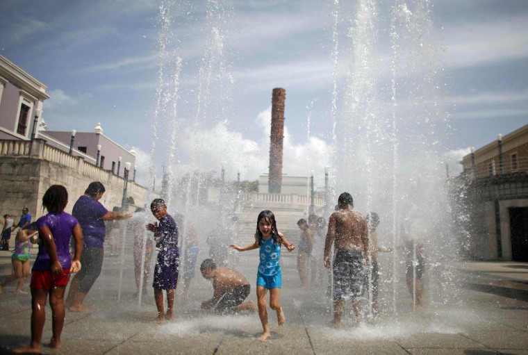 Image: Children cool off at a water fountain during the Summer Solstice in Old San Juan, Puerto Rico on June 21, 2013.