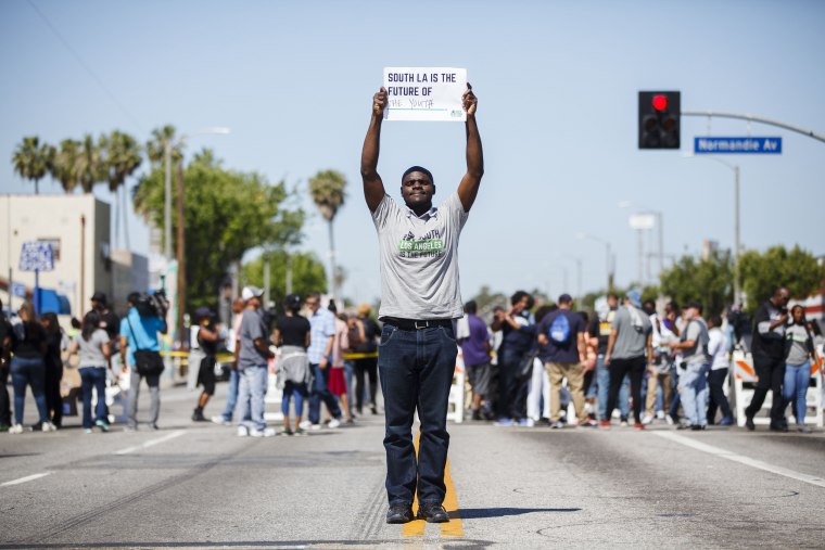 Image: A peace activist participates in a rally on the 25th anniversary of the LA riots