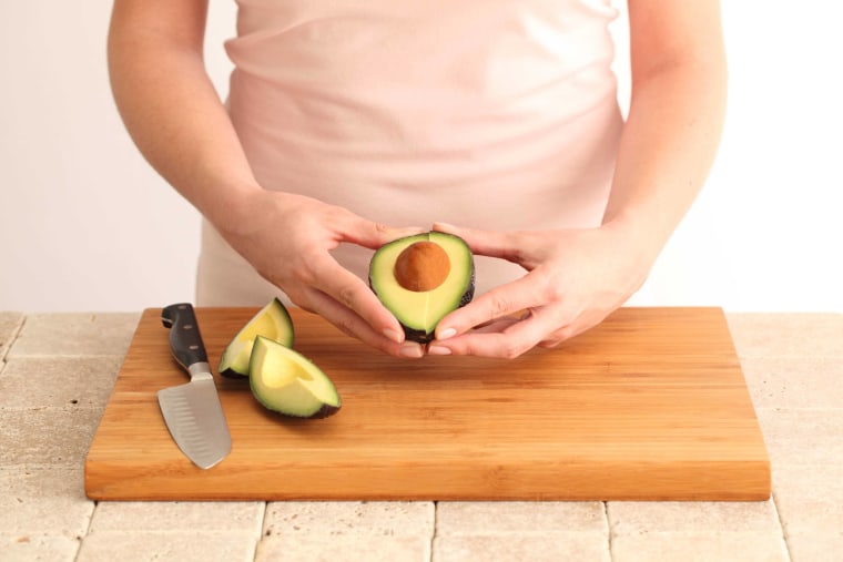 Slicing an avocado into quarters makes it easier to the remove the pit and skin, according to the California Avocado Commission.