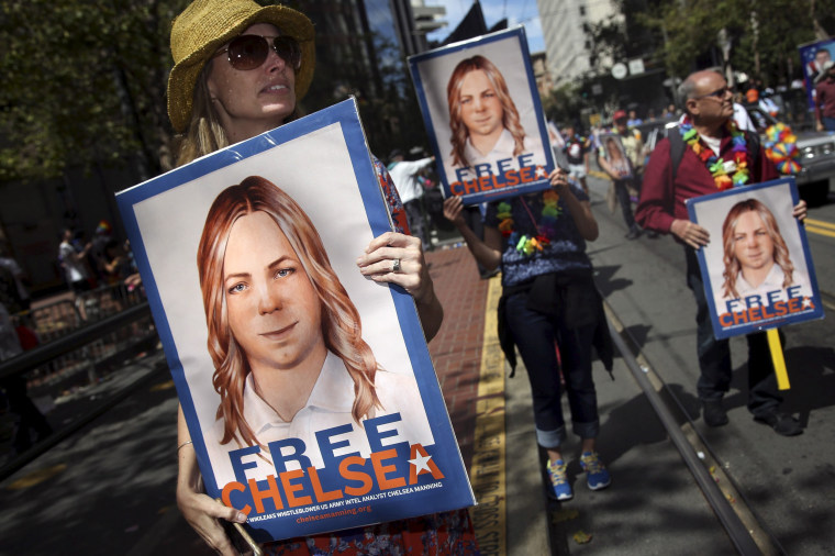 Image: People hold signs calling for the release of imprisoned wikileaks whistleblower Chelsea Manning