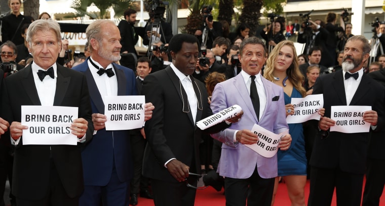 Image: The cast of The Expendables 3 hold up banners reading "Bring Back our Girls"