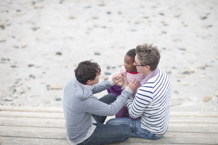 Gay couple and child at beach