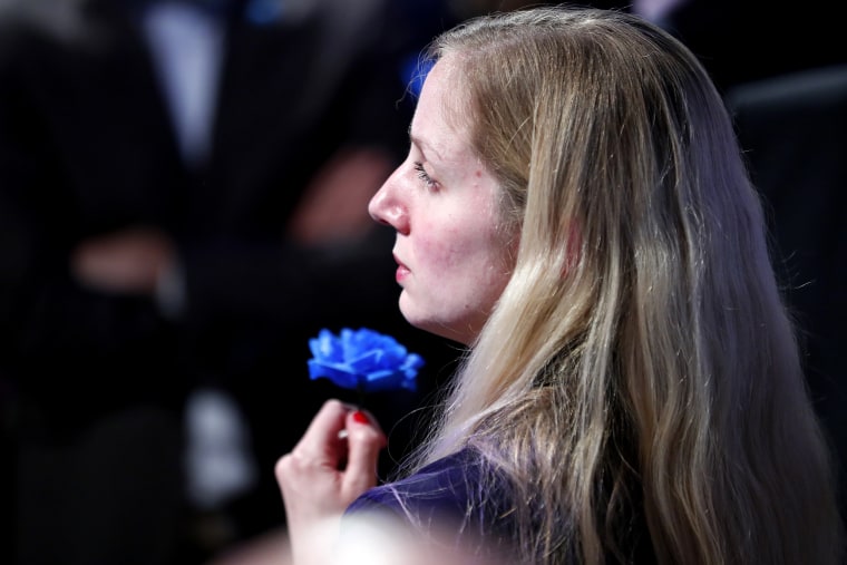 Image: A supporter of Marine Le Pen holds a blue flower