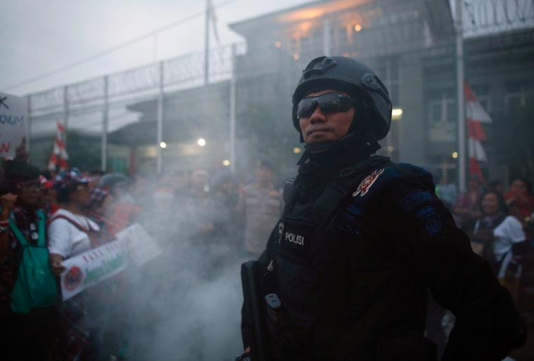 Image: A police officer stands guard during a protest by supporters of Jakarta Governor Basuki Tjahaja Purnama outside Cipinang Prison