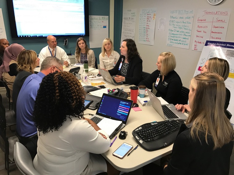 Image: Image: Patsy Stinchfield, Sr. Director of Infection Prevention, Skin Integrity, and The Children's Immunization Project leads a meeting on the measles outbreak in the command center