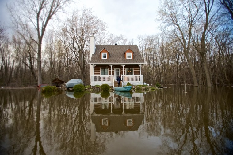 Image: A house is surrounded by floodwaters in Pointe-Calumet, Quebec