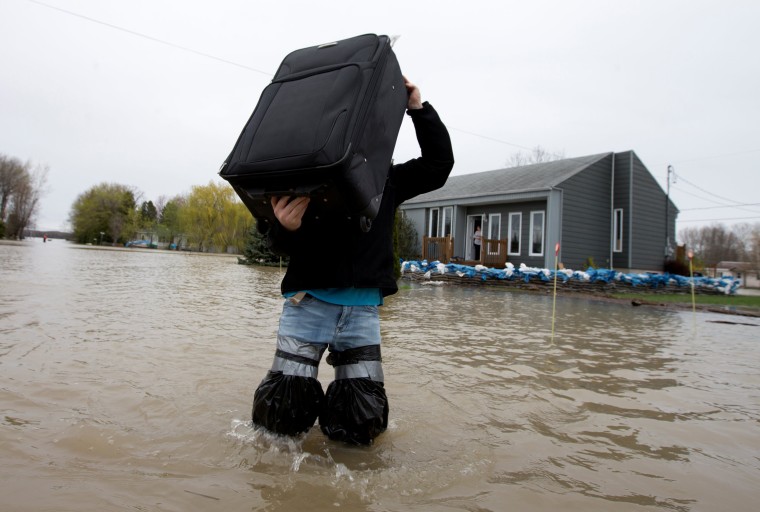 Image: A resident removes belongings from his home in a flooded residential neighbourhood in Rigaud, Quebec