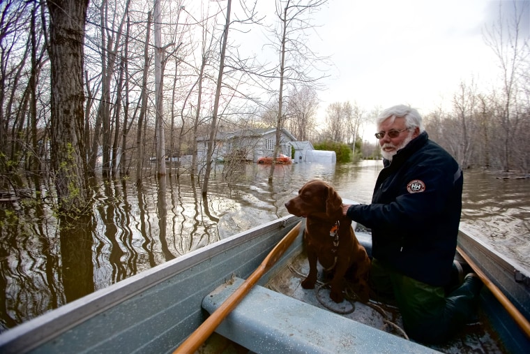 Image: Michel Guerard and his dog Choco return with their boat to help their neighbors evacuate