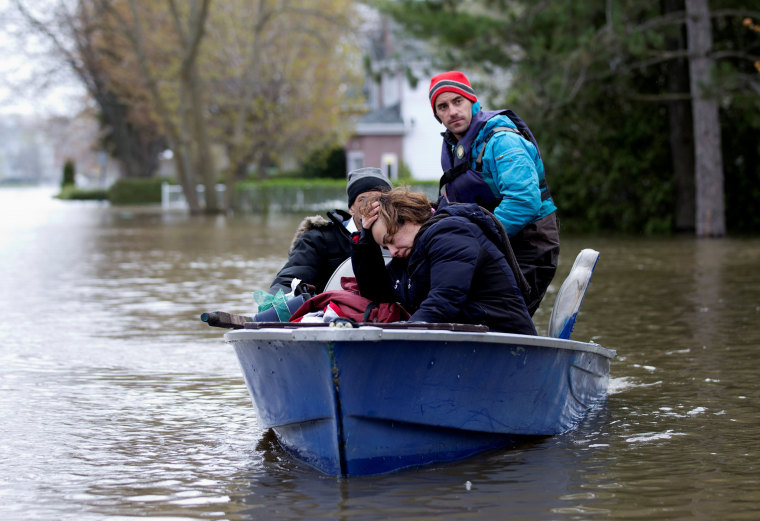 Image: Mina Tayarani is evacuated from her home in a flooded residential neighbourhood in Ile Bizard, Quebec, Canada