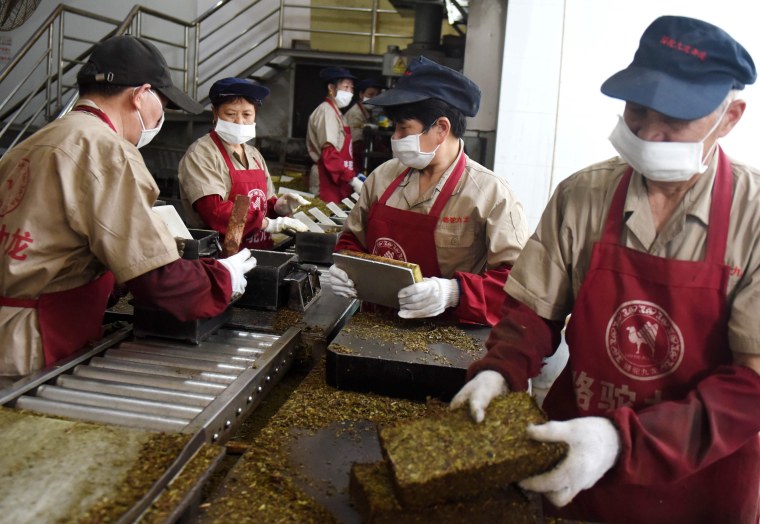 Image: Workers package bricks of tea leaves for export in Wuyi, China