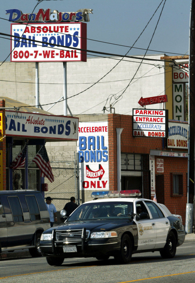 Image: A Los Angeles County Sheriff's car drives past bail bonds businesses