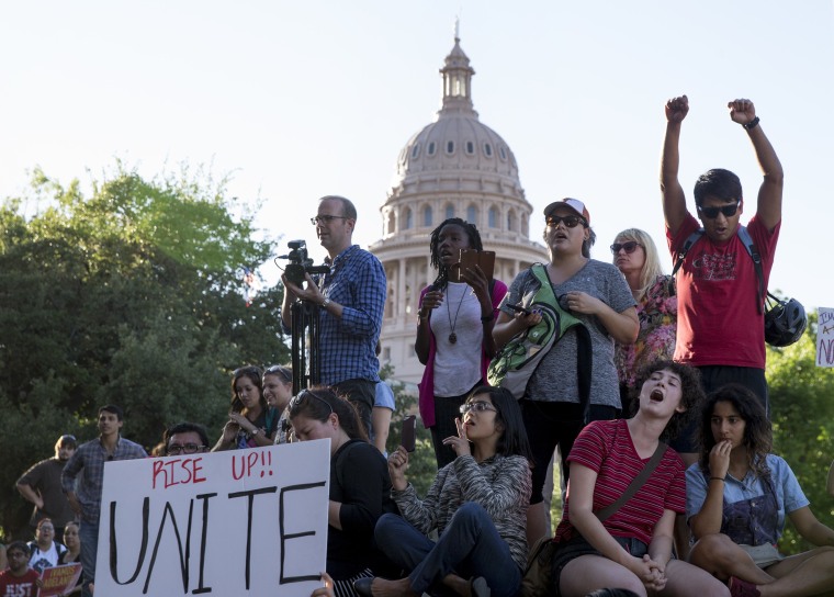 Image: Protesters, who are against the Senate Bill 4 Sanctuary Cities ban, rally outside the Texas Department of Insurance building