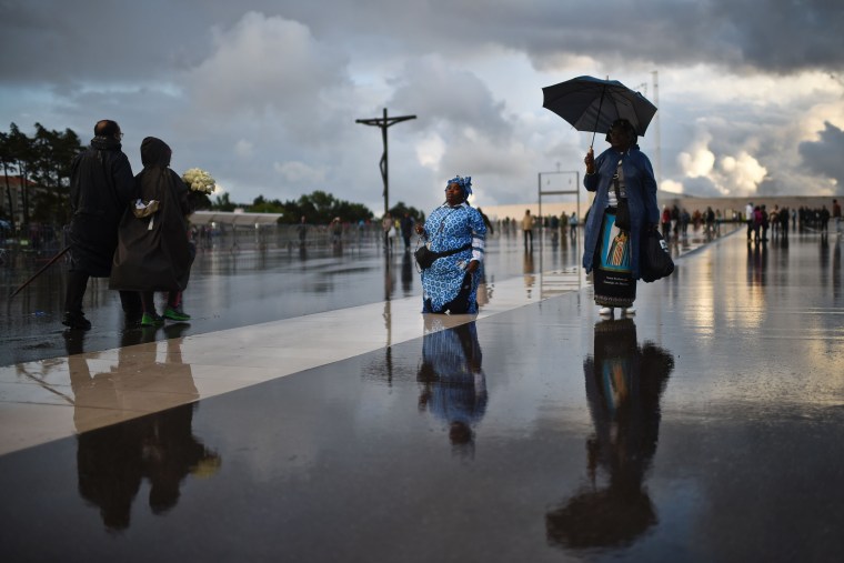 Image: A woman on her knees before a shrine in Fatima