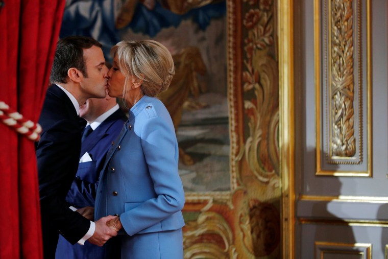 Image: French President Emmanuel Macron kisses his wife Brigitte Trogneux during the handover ceremony in Paris