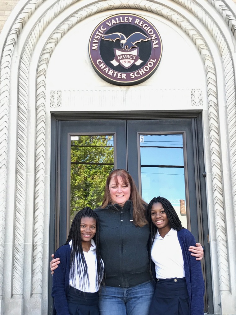 Deanna and Mya Cook pose with their mom, Colleen, in front of their school. 