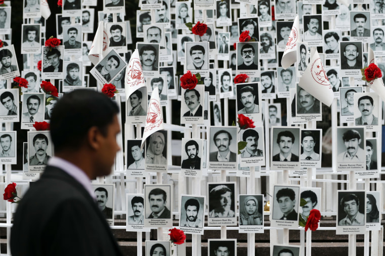 Image: A man looks at photos of some of the people executed in Iran during a rally outside the United Nations