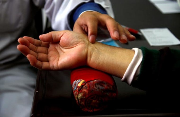 A diabetes patient has her pulse checked by a diabetes specialist doctor during a medical check-up at a hospital in Beijing