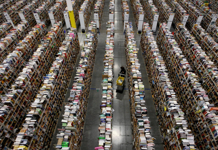 Image: A worker gathers items for delivery at Amazon's distribution center in Phoenix