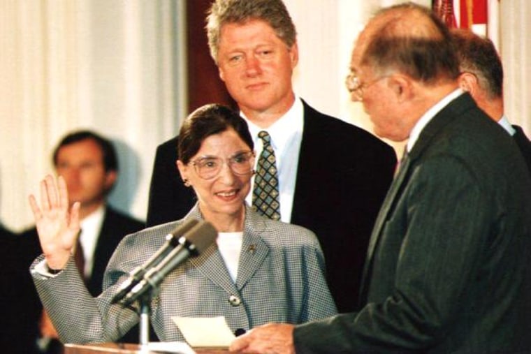 Chief Justice of the U.S. Supreme Court William Rehnquist (R) administers the oath of office to newly-appointed U.S. Supreme Court Justice Ruth Bader Ginsburg (L) as President Bill Clinton looks on 10 August 1993.