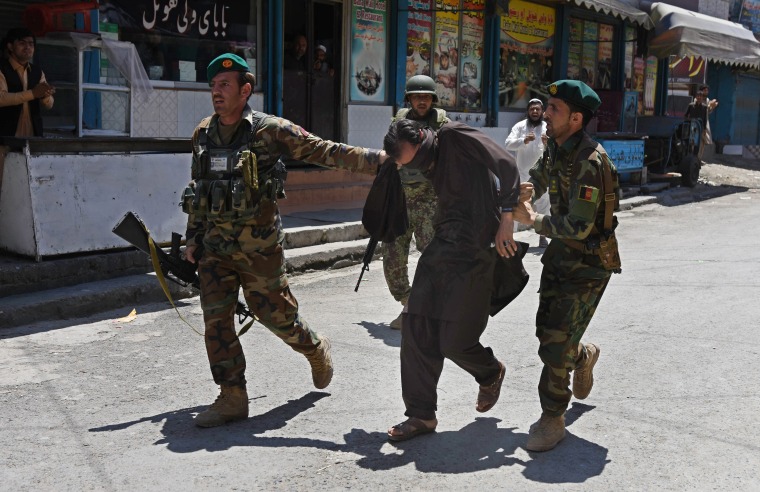 Image: Afghan soldiers capture a suspected militant after the Jalalabad attack.