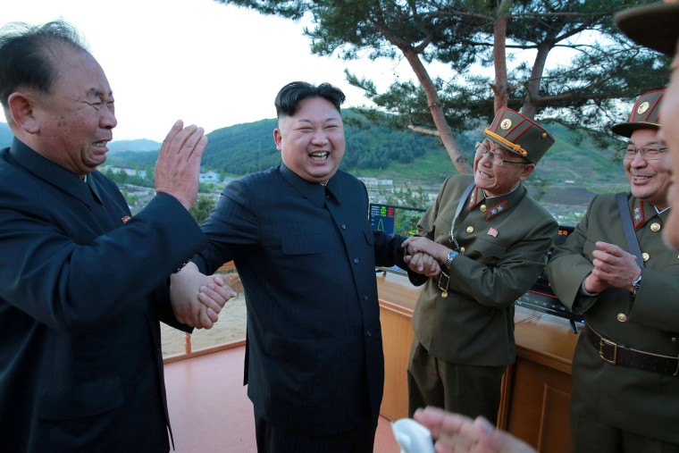 Image: North Korean leader Kim Jong Un reacts with members of the Korean People's Army scientists and engineers