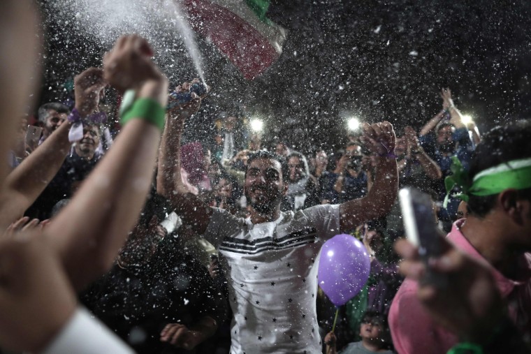 Image: Supporters of newly re-elected Iranian President Hassan Rouhani dance during a gathering to celebrate his victory