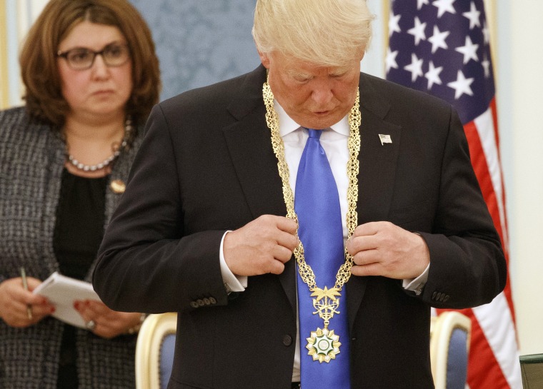 Image: President Donald Trump looks at the Collar of Abdulaziz Al Saud Medal during a ceremony at the Royal Court Palace,
