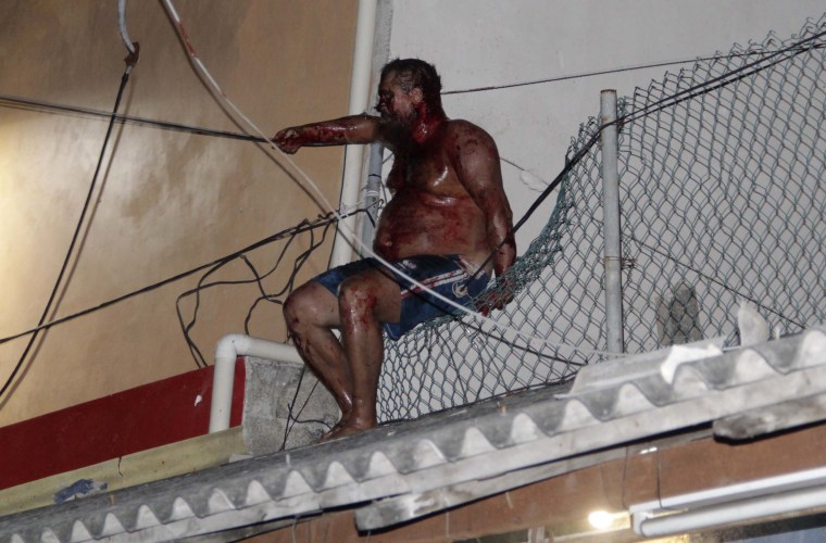 Image: A man sits covered in blood after an angry mob attacked him for reportedly insulting Mexicans