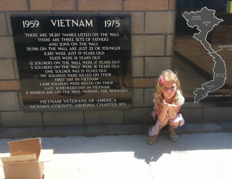 Brandy Phillips' 4-year-old daughter, Serenity Hopkins, prepares to hide a painted rock at a memorial site.