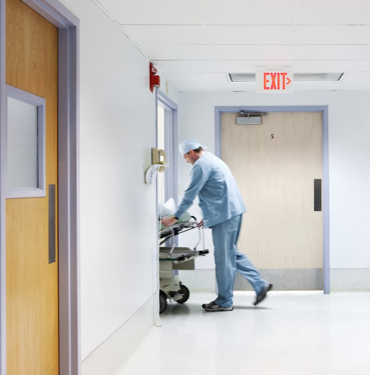 Anesthesiologist wheeling patient into surgery