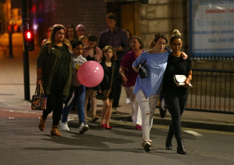 Image: Police escort members of the public from the Manchester Arena