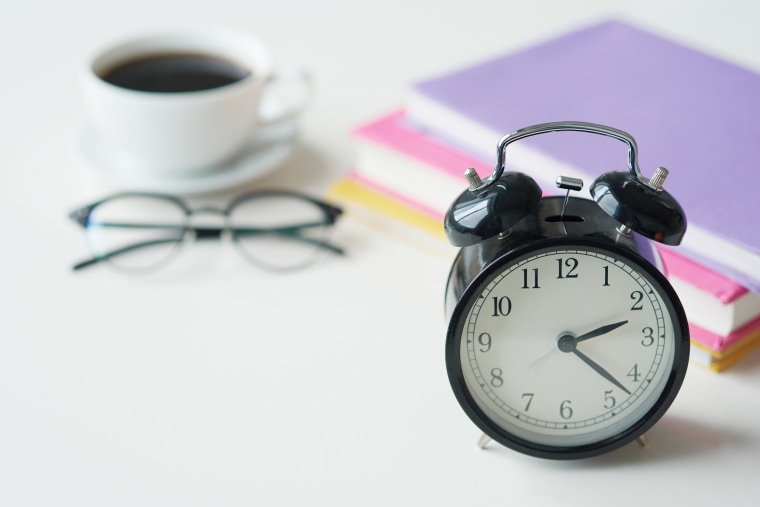 Image: An alarm clock and a cup of coffee