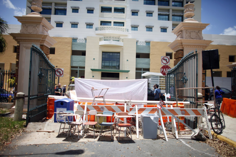 FILE- The University of Puerto Rico's main gate is barricaded during a protest against a tuition increase in San Juan, Puerto Rico, Wednesday, April 23, 2014.