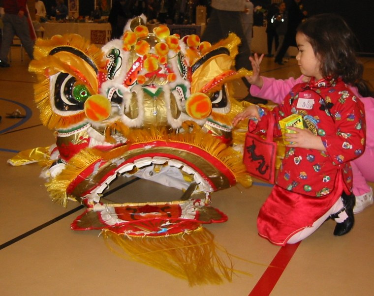 Frances Kai-Hwa Wang's daughter meeting a Chinese lion up close for the first time at a Chinese New Year's cultural event