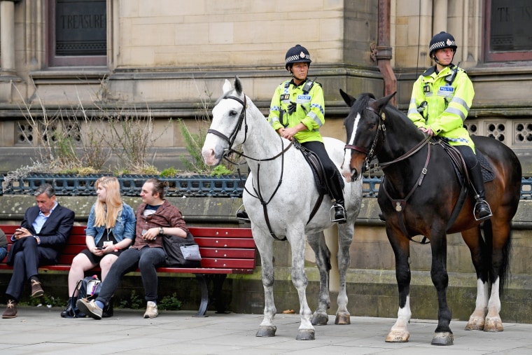 Image: Mounted Police patrol as members of the public lay floral tributes and messages in Manchester