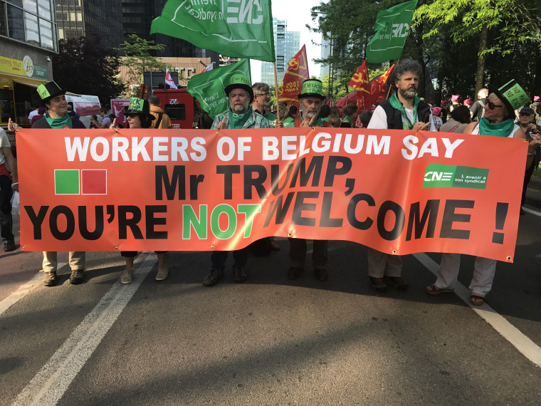 Belgian trade unionists hold up an anti-Trump banner during a protest against Donald Trump's visit on Wednesday.