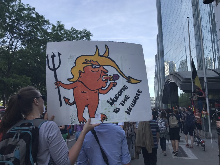 Image: A woman holds up an anti-Trump placard during a rally in Belgium