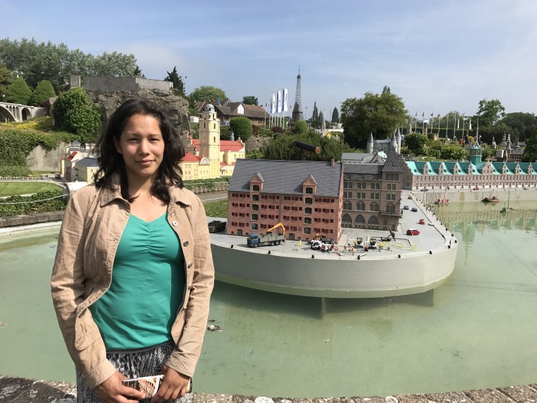 Image: Kerstin Maas-Enriquez poses in front of a miniature version of the Copenhagen stock exchange in Mini-Europe amusement park