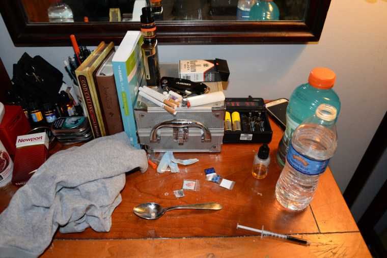 Drug paraphernalia and baggies of heroin displayed on the desk of one of the two drug counselors who died of overdoses at the Freedom Ridge Recovery Lodge.