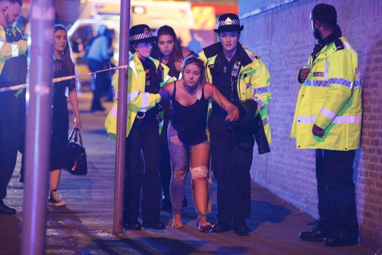 Image: An injured fan is helped by police and emergency personnel at the Manchester Arena after an explosion